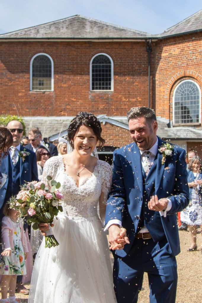 Bride and Groom in confetti after weeding ceremony at Kings Chapel, Old Amersham, Buckinghamshire