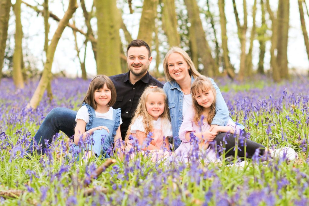 Photo of family including 3 girls in bluebell woodland in Hertfordshire countryside by Tanya Aldcroft Photography