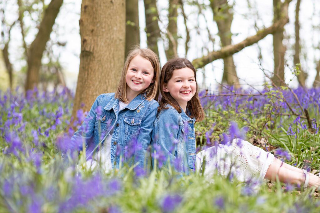 Sisters sitting amongst bluebells, Hertfordshire
